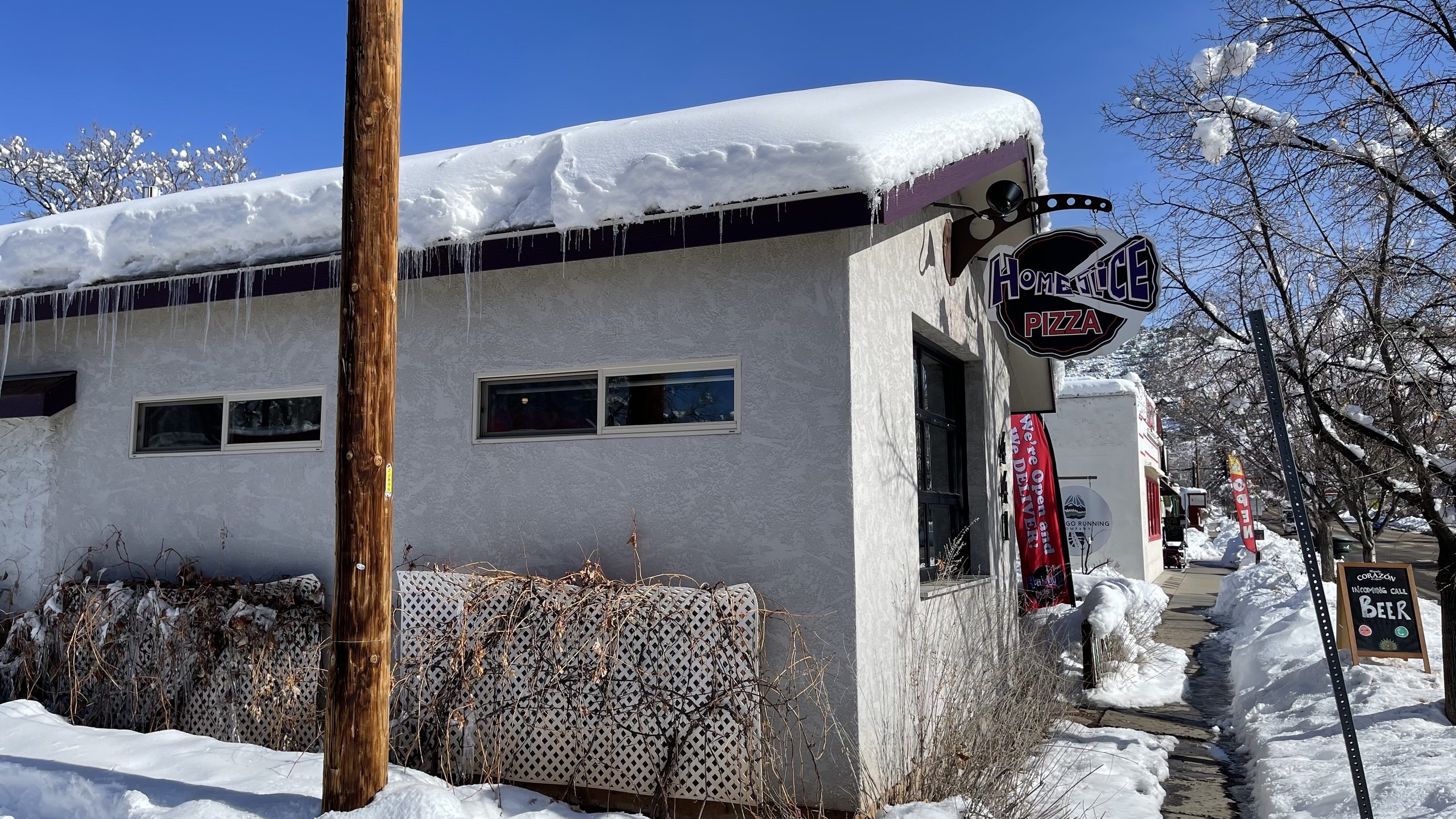 A snowy winter exterior at HomeSlice Pizza College Drive