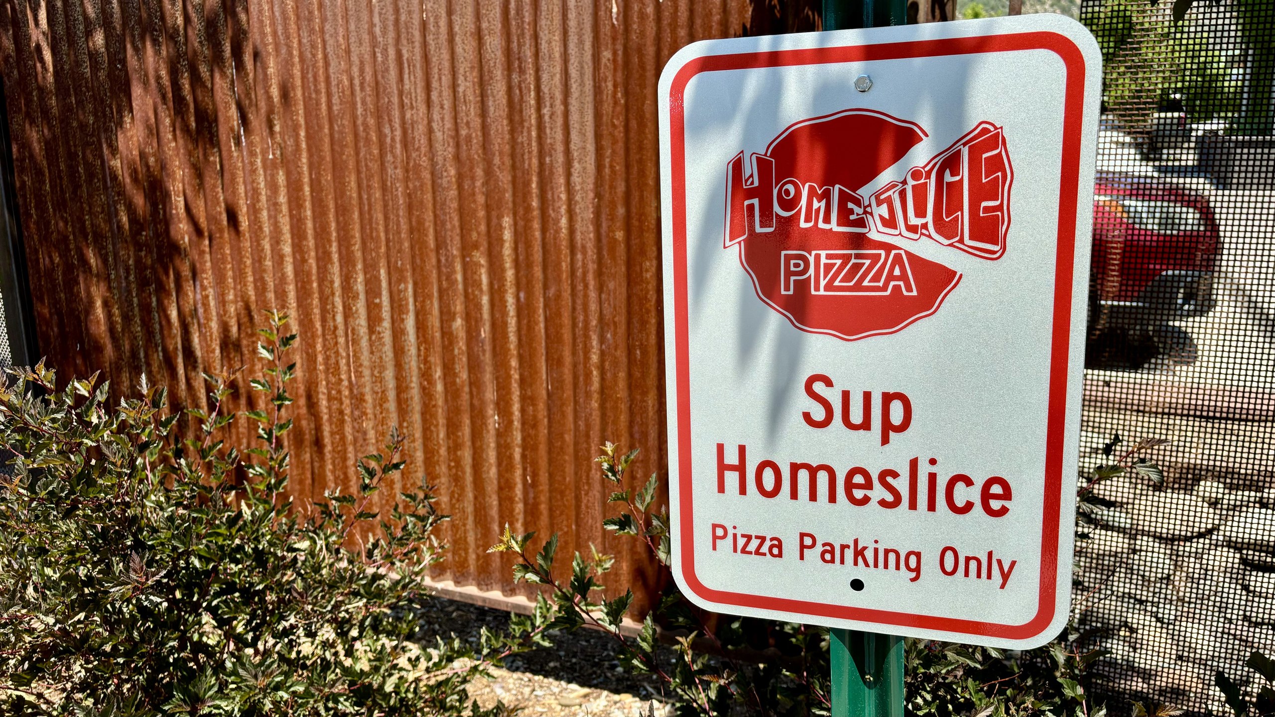 The “Sup Homeslice — Pizza Parking Only” sign at North Main
