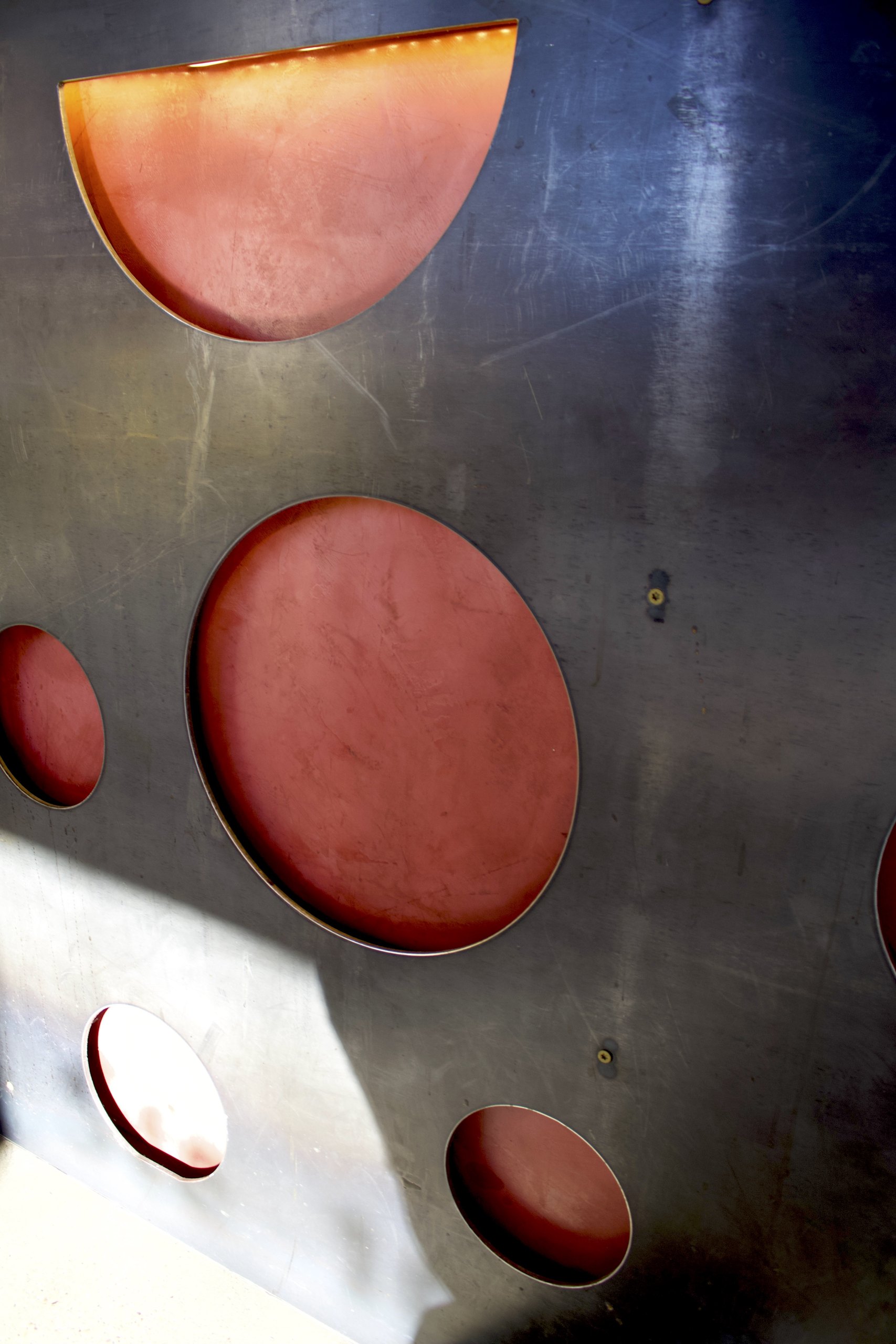 The wall of pizza pans with slice-shaped cutouts, a HomeSlice decor signature