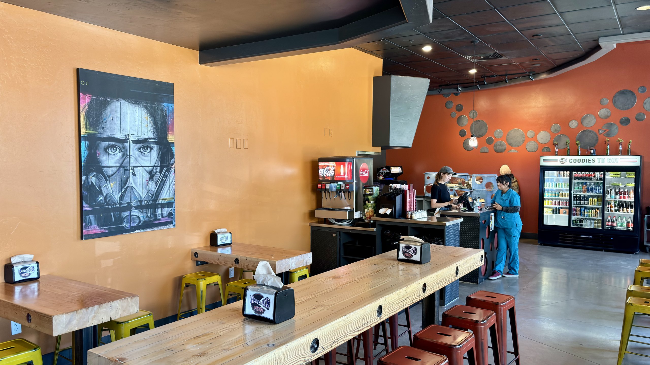 The Three Springs dining room with pizza-pan wall art